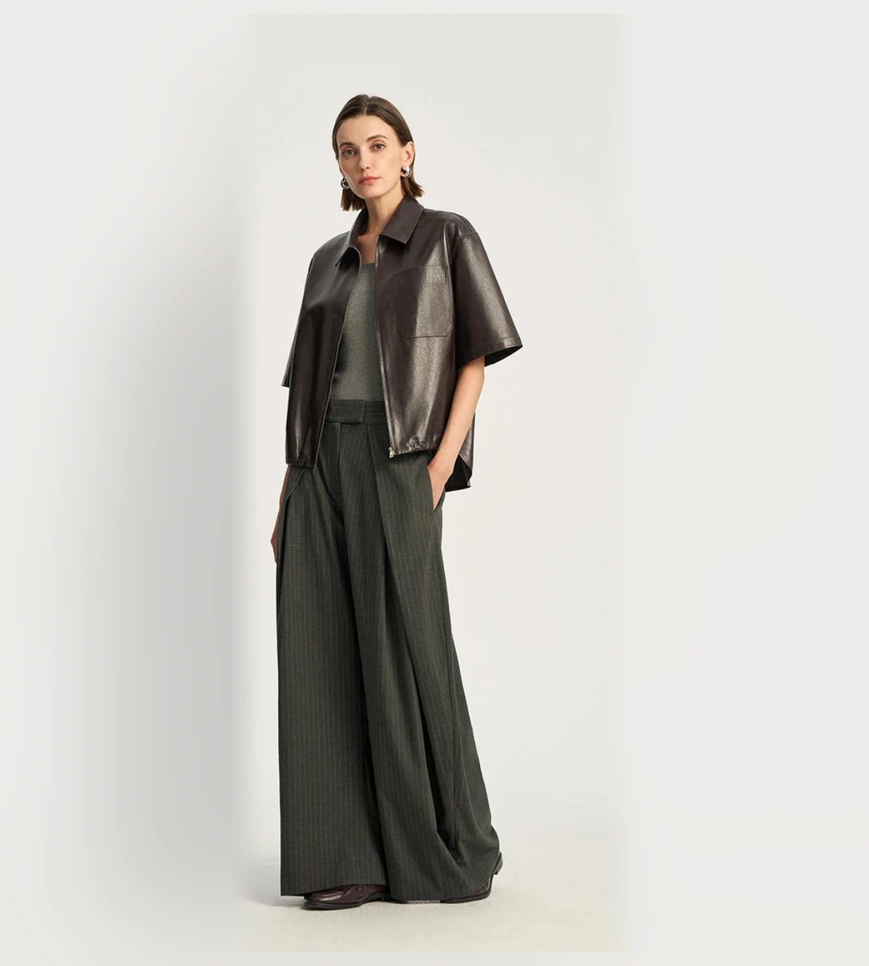 身着深色短袖皮衣与阔腿长裤的女士造型